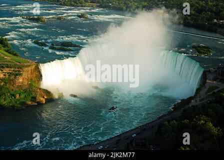 Die Maid of the Mist Tour Boot fährt in das Horseshoe der Canadian Falls in Niagara Falls, während der Nebel aus dem Fluss steigt in einer Luftaufnahme Stockfoto