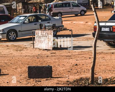 Johannesburg Südafrika - August 15 2007; Werkbank und Schild bieten eine Reihe von Fahrzeug-Dienstleistungen auf staubigen Straßenrand in Soweto Stockfoto