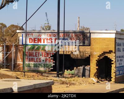 Johannesburg Südafrika - August 15 2007; Alte einstürzende Backsteingebäude bleibt von Geschäftsschildern am Straßenrand der Stadt erhalten. Stockfoto