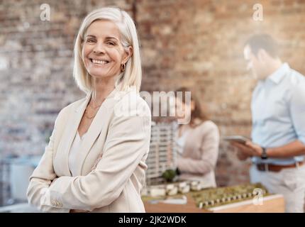 Selbstbewusster, erfolgreicher und fröhlicher Architektenmanager, der ein Team von Baudesignern im Büro leitet. Porträt einer lächelnden, glücklichen und ehrgeizigen Frau mit Stockfoto