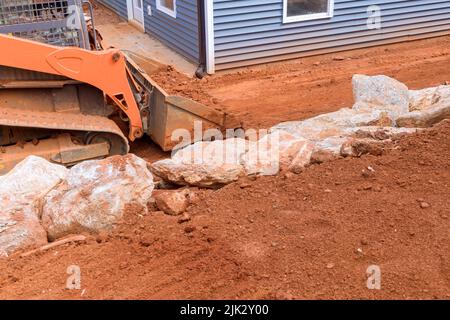 Während der Landschaftsarbeiten auf der Baustelle führt ein Bulldozer Arbeiten mit Erdboden durch Stockfoto