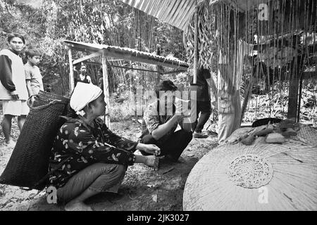 Dorf Uluk Palin, Putusibau Utara, Kapuas Hulu, West Kalimantan, Indonesien. März 2007. Familie des neuen traditionellen Anführers der Sungulo Palin Tamambaloh Longhouse Gemeinschaft, die 40 Tage nach dem Tod des ehemaligen traditionellen Anführers dieser traditionellen Gemeinde einen Besuch auf dem Friedhof, auf dem ihr Vater begraben ist, durchführt. Stockfoto