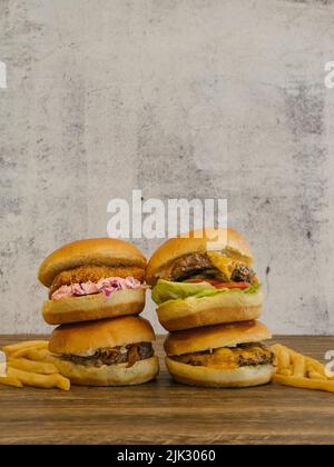 Vier Burger, zwei gestapelt, mit Pommes Frites an der Seite Stockfoto