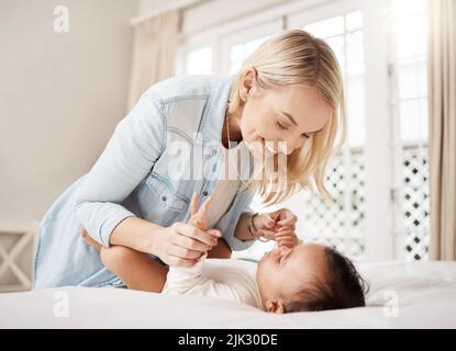 Sind Sie bereit für einen weiteren lustigen Tag. Eine Frau, die sich zu Hause mit ihrem Baby verklebt. Stockfoto