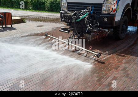 Eine spezielle Maschine wäscht Stadtwege und Straßen mit Wasser Stockfoto