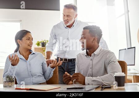 Ergebnisse zu liefern, ist das, was sie tun. Eine Gruppe von Geschäftsleuten, die in einem modernen Büro ein Meeting abhalten. Stockfoto