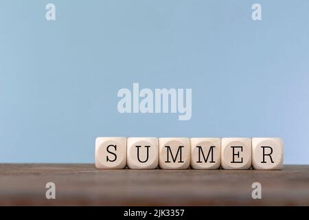 Sommerwort in Holzwürfel auf Holztisch geschrieben Stockfoto