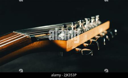 Nahaufnahme des Gitarrenkopfes. E-Gitarre Kopfteil auf schwarzem Hintergrund Stockfoto