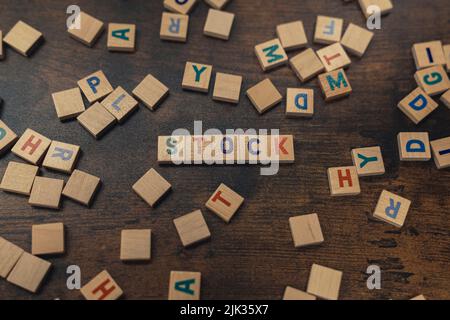 Verstreute Holzbriefe auf einem dunklen Holztisch. Bunte Buchstaben, die den WORTBESTAND erzeugen. . Hochwertige Fotos Stockfoto