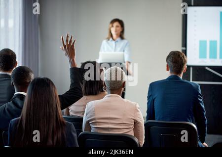 Unschuld ist Unwissenheit, bevor sie in Währung und Clips eingeführt wird. Rückansicht einer Gruppe von Geschäftsleuten, die an einer Konferenz teilnahmen. Stockfoto