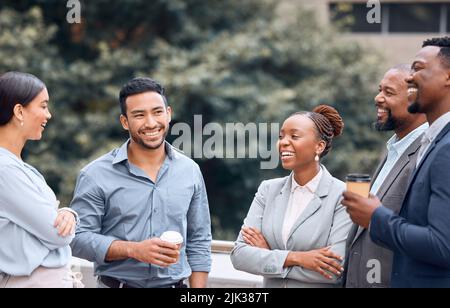 Lernen Sie meine Kollegen kennen. Eine Gruppe von Geschäftsleuten, die draußen Kaffee trinken und sich unterhalten. Stockfoto