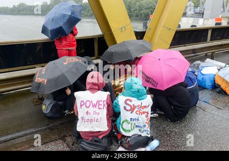 DEUTSCHLAND, Hamburg, Aktivisten von deCOALonize europe blockieren die Kattwyk-Brücke in der Nähe des Kohlekraftwerks Moorburg, um gegen die Kohleverbrennung und Steinkohlenimporte und den Waffenhandel von Rheimetall zu protestieren Stockfoto