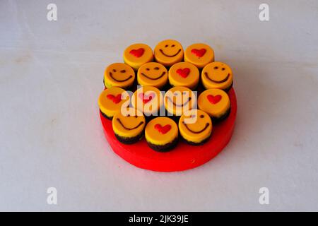 Kleine gelbe Kuchen mit Herdform und Smiley Stockfoto