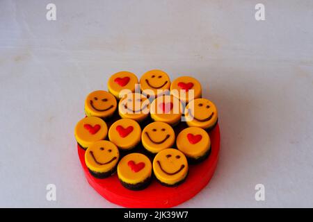 Kleine gelbe Kuchen mit Herdform und Smiley Stockfoto