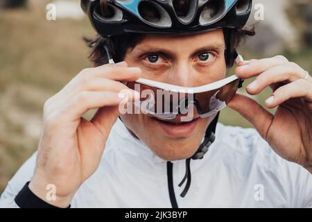 Nahaufnahme Porträt eines professionellen Radfahrers, eines Erwachsenen mit Helm und einer Schutzbrille Stockfoto