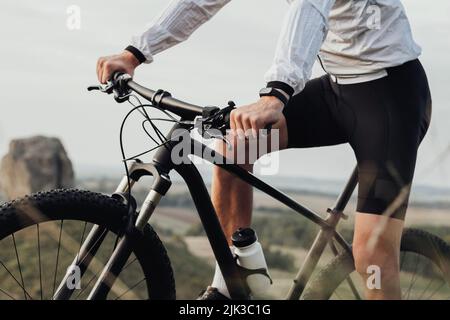 Cropped unkenntlich professioneller Radsportler, der auf seinem Fahrrad im Freien sitzt, Sportsman, der auf dem Trail Track reitet Stockfoto