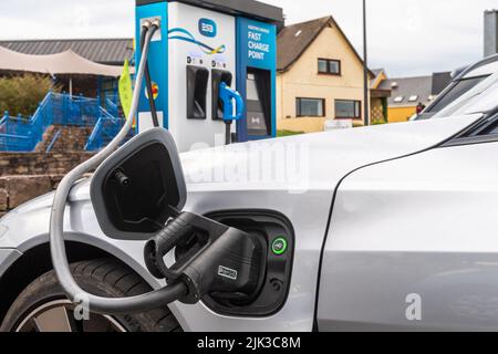 Laden eines Elektroautos an einer ESB-Schnellladestelle in Dingle, County Kerry, Irland. Stockfoto