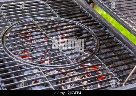Grillgerät mit Grillrost. Heiße Kohlen zum Kochen von Steaks. Stockfoto