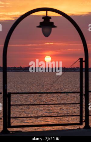 Thorpe Bay, Southend on Sea, Essex, Großbritannien. 30. Juli 2022. Die Sonne ist hinter der Thorpe Bay Area von Southend on Sea aufgegangen, um einen hellen und warmen Morgen zu beginnen. Vom Southend Pier aus gesehen. Stockfoto