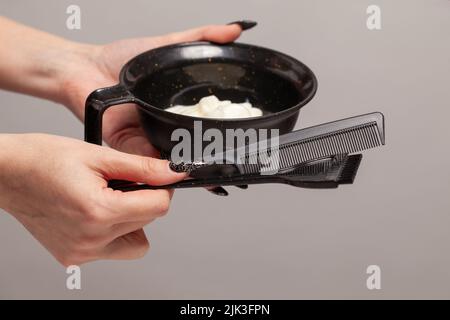 Stylistin Hände mit Haarfärbemittel in schwarzer Schale Stockfoto