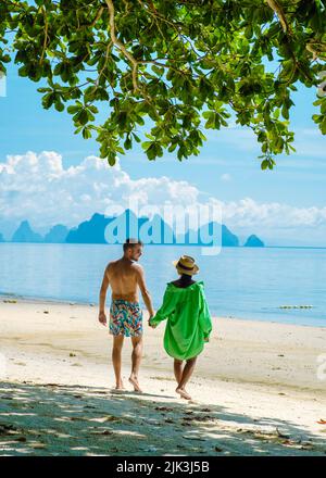 Ein Paar Männer und Frauen am Strand der tropischen Insel Naka Island in der Nähe von Phuket Thailand, eine Frau an einer Schaukel am Strand und ein Mann an einem tropischen Strand mit einer Schaukel am Strand Stockfoto