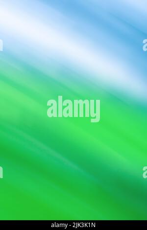 Frühlingslandschaft mit Wiesen im Sonnenlicht defokussieren unscharfe Kulisse. Abstrakte verschwommene Landschaft mit blauem Himmel. Stockfoto