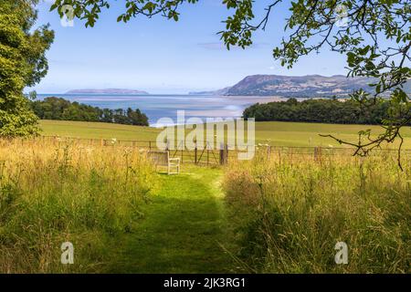 Der Blick auf die Küste in Richtung Great Orme vom Gelände des Penrhyn Castle, Gwynedd, Nordwales Stockfoto