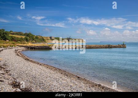 Der alte Penmon Quay mit dem Penmon Quarry im Hintergrund, Isle of Anglesey, Nordwales Stockfoto