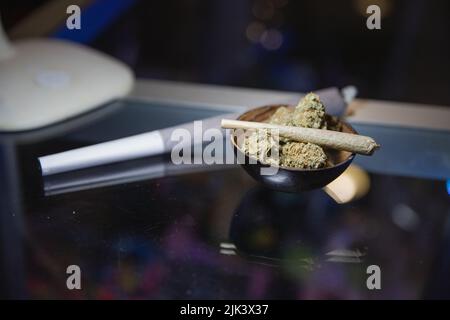 Ein gerolltes Gelenk von Marihuana, das auf rohen Marihuanaknospen, Drogen- und Suchtkonzept ruht Stockfoto