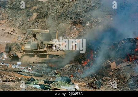 (LOGISTIKBEREICH ANACONDA, Balad, Irak) - Sgt. Richard Ganske, 84. Combat Engineer Battalion verwendet einen Bulldozer, um den Abfall in die Brandgrube zu leiten, sie zu sortieren und zu verbrennen, um die sanitären Anforderungen von LSA Anacondas zu erfüllen. Stockfoto