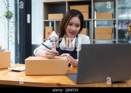 Kleinunternehmen ein neues Start-up in der Gegenwart für Online-Shop. Von Frau Besitzer haben ein Lager verwendet, um an Kunden zu senden. KMU-Unternehmerkonzept Stockfoto