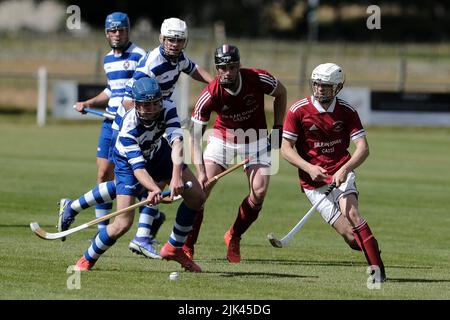 Newtonmore, Großbritannien. 30 Juli 2022. Newtonmore Camanachd Club First Team spielt Kinlochshiel auf der Eilan in der Mowi Premiership. Kingussie (in weiß und blau) gegen Kinlochshiel. Endergebnis 2-2. MOWI Premiership Ligaspiel. Shinty, oder „Camanachd“ in Schottland, ist ein Spiel, das nur in den Highlands zwischen Teams gespielt wird, die Dörfer und Städte repräsentieren. Das Spiel ist älter als die aufgezeichnete Geschichte Schottlands und wird auf einem Rasen mit einem kleinen Ball und Stöcken (genannt Caman) gespielt. . Kredit: Rob Gray/Alamy Live Nachrichten Stockfoto