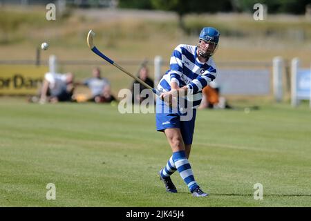 Newtonmore, Großbritannien. 30 Juli 2022. Newtonmore Camanachd Club First Team spielt Kinlochshiel auf der Eilan in der Mowi Premiership. Kingussie (in weiß und blau) gegen Kinlochshiel. Endergebnis 2-2. MOWI Premiership Ligaspiel. Shinty, oder „Camanachd“ in Schottland, ist ein Spiel, das nur in den Highlands zwischen Teams gespielt wird, die Dörfer und Städte repräsentieren. Das Spiel ist älter als die aufgezeichnete Geschichte Schottlands und wird auf einem Rasen mit einem kleinen Ball und Stöcken (genannt Caman) gespielt. . Kredit: Rob Gray/Alamy Live Nachrichten Stockfoto