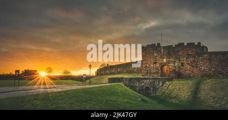 Carlisle Castle Sonnenuntergang mit De Ireby's Turm und Laternenpfosten. Stockfoto