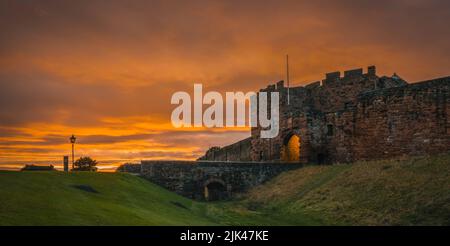 Carlisle Castle bei Sonnenuntergang mit De Ireby's Tower und Brücke über dem äußeren Burggraben. Stockfoto