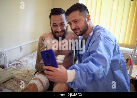 Odessa, Ukraine. 29.. Juli 2022. Der ukrainische Präsident Wolodymyr Zelenskyy, rechts, macht ein Selfie mit einem Soldaten, der während eines Besuchs mit verwundeten Kriegern während eines Krankenhausaufenthalts verletzt wurde, der ukrainische Verteidiger am 29. Juli 2022 in Odessa, Ukraine, behandelt. Kredit: Ukrainisches Presidential Press Office/Ukraine Presidency/Alamy Live News Stockfoto