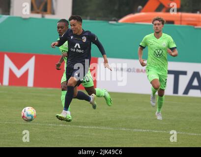 Jena, Deutschland. 30.. Juli 2022. Fußball: DFB-Pokal, FC CZ Jena - VfL Wolfsburg, 1.. Runde, Ernst-Abbe-Sportfeld. Um den Ball kämpfen Wolfskis Ruidle Baku (l) und Jenaers Pasqual Verkamp. Kredit: Bodo Schackow/dpa - WICHTIGER HINWEIS: Gemäß den Anforderungen der DFL Deutsche Fußball Liga und des DFB Deutscher Fußball-Bund ist es untersagt, im Stadion und/oder vom Spiel aufgenommene Fotos in Form von Sequenzbildern und/oder videoähnlichen Fotoserien zu verwenden oder zu verwenden./dpa/Alamy Live News Stockfoto