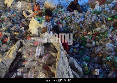 Die Arbeiter sahen in einer Werkstatt Plastikflaschen sortieren, bevor sie sie zum Recycling schickten. Plastikflaschen werden recycelt und zu Polyester umgewandelt, das in Kleidungsstücken und Trikots auf der ganzen Welt verwendet wird. Viele Länder haben damit begonnen, Einweg-Kunststoffe zu verbieten, um die Umweltprobleme anzugehen. Stockfoto