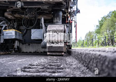 Rückansicht einer Kaltfräsmaschine und Schnitt Asphalt auf der Straße Stockfoto