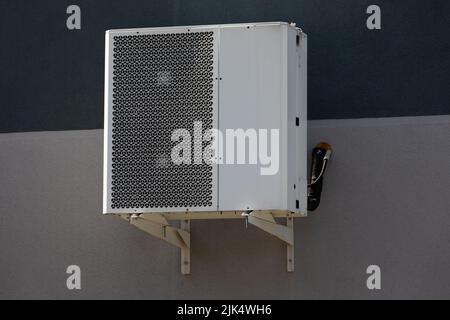 An der Gebäudewand hängende Kühleinheit für die Kanalklimaanlage Stockfoto