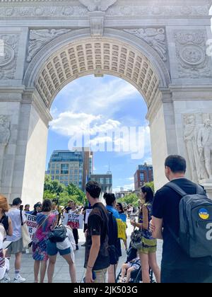 Die Teilnehmer versammelten sich zu einem Foto mit ukrainischer Flagge vor dem Washington Square Park Arch in Manhattan, New York City, um Ukrai zu unterstützen Stockfoto