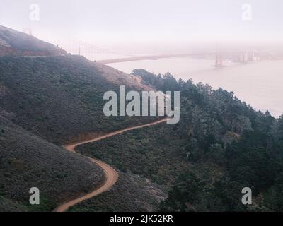 Blick von der Spitze des Hügels, Golden Gate Bridge an einem nebligen Julinachmittag. Stockfoto