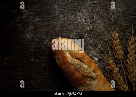 Baguette-Laib mit frischem Brot und Samen im rustikalen Stil. Hausgemachtes gesundes Brot backen Stockfoto