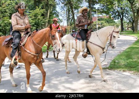 Reiter und ihre Pferde nehmen am Gruppenritt zum Lakefront und zurück Teil, während der jährlichen High Noon Ride 33. im Washington Park, Chicago USA, am 30. Juli 2022. Dies ist eine Wiedervereinigung von Chicagos „Black Cowboys“, die seit 1989 vom Broken Arrow Riding Club organisiert wird. Diese Cowboys und Cowgirls bringen ihre Pferde zum Washington Park für eine Gruppenfahrt zum Lakefront und zurück. Diese Zusammenkunft und Ausritt ist ein Beispiel für ihre geschichtsträchige Kultur und eine Chance, junge Kinder mit Pferden vertraut zu machen. (Foto: Alexandra Buxbaum/Sipa USA) Stockfoto