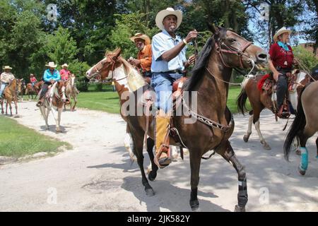 Reiter und ihre Pferde nehmen am Gruppenritt zum Lakefront und zurück Teil, während der jährlichen High Noon Ride 33. im Washington Park, Chicago USA, am 30. Juli 2022. Dies ist eine Wiedervereinigung von Chicagos „Black Cowboys“, die seit 1989 vom Broken Arrow Riding Club organisiert wird. Diese Cowboys und Cowgirls bringen ihre Pferde zum Washington Park für eine Gruppenfahrt zum Lakefront und zurück. Diese Zusammenkunft und Ausritt ist ein Beispiel für ihre geschichtsträchige Kultur und eine Chance, junge Kinder mit Pferden vertraut zu machen. (Foto: Alexandra Buxbaum/Sipa USA) Stockfoto