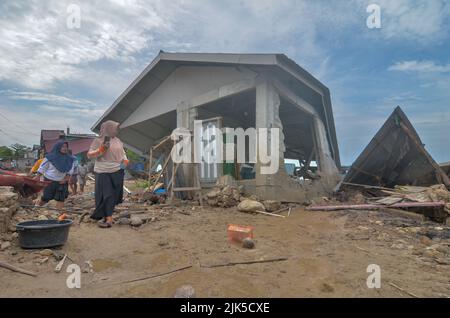 Parigi Moutong, Indonesien. 29.. Juli 2022. Die Gemeinde von Torue in Parigi Moutong Regency, Zentral-Sulawesi, Indonesien, versucht Gegenstände zu finden, die noch aus einem Hausgebäude gerettet werden konnten, das aufgrund der Sturzflut, die das Dorf am 28. Juli 2022 heimgesucht hatte, mit Schlamm begraben wurde. Nach Angaben des Joint SAR-Teams waren 3 Menschen gestorben und vier Bewohner wurden immer noch vermisst. (Foto: Wahono/Pacific Press/Sipa USA) Quelle: SIPA USA/Alamy Live News Stockfoto