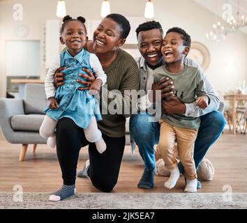 Familienliebe, es gibt nichts Vergleichtes. Porträt einer glücklichen jungen Familie, die ihre Zeit zu Hause verbringt. Stockfoto