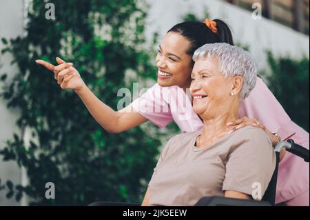 Wenn Sie nach Schönheit suchen, werden Sie sie überall finden. Eine junge Krankenschwester, die sich um eine ältere Frau im Rollstuhl kümmert. Stockfoto