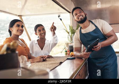 Das klingt köstlich. Zwei Freunde, die Lebensmittel von einem Food Truck bestellen. Stockfoto