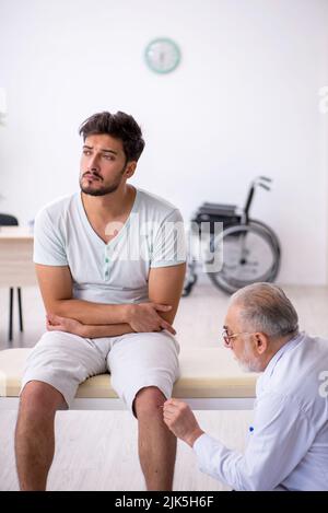 Junger Patient besucht alten männlichen Arzt Neurologe Stockfoto